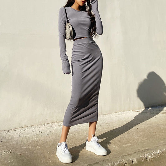 斜めから見たグレーセットアップで、クロップド丈トップとタイトスカートのバランスが魅力的