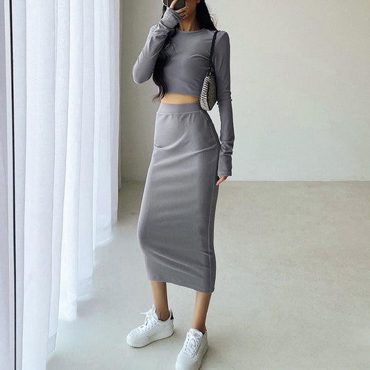 グレーの長袖クロップドトップ&ハイウエストスカートセットアップを正面から撮影し、脚長シルエットが際立つ