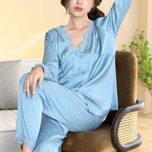 椅子に座った姿勢でブルーの上下セットを着用。Vネックのレース襟が首元を華奢見えさせる