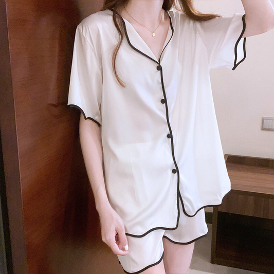 ホワイトのシルク調シャツパジャマを立った状態で正面から撮影。黒パイピングがアクセントになったVネックトップス。