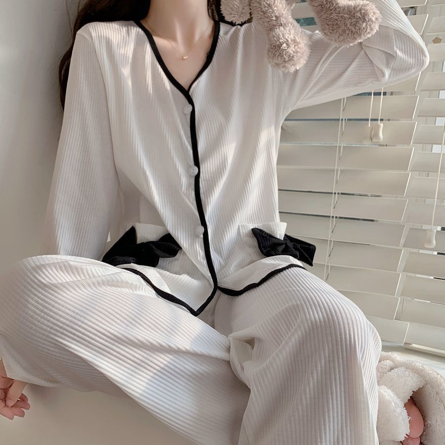 ホワイトのパンツを着用し、リボン付きトップスのポケットをアピール。可愛さと色気を両立するルームウェア