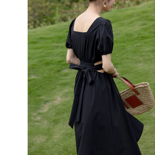 背面から撮影したブラックフレアワンピースで、パフスリーブとスクエアバックのラインが上品