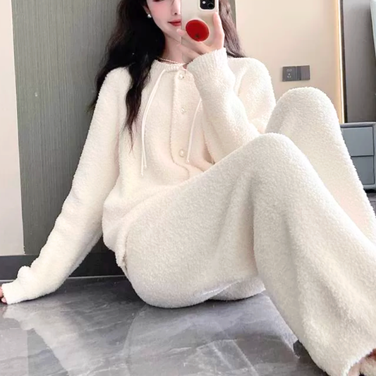 床に座った女性がふわもこルームウェアを着てくつろぐカット。リラックス感があり、彼氏ウケ・旦那ウケのおうち時間コーデに最適なアイボリーセットアップ。