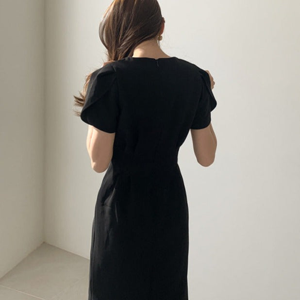 ブラックのVネックパフスリーブタイトワンピースを背面から撮影。程よいフィット感が大人っぽい雰囲気を演出