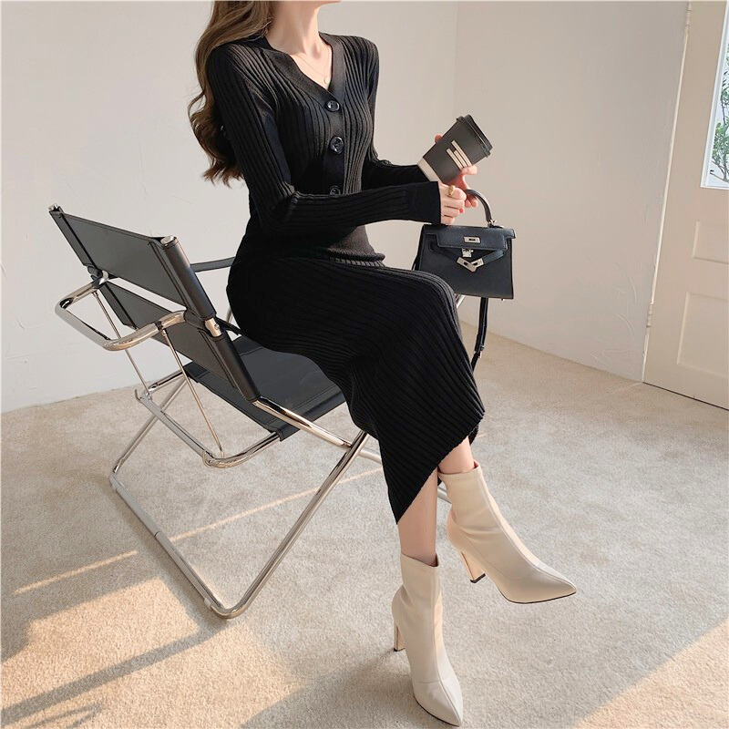 ブラックのタイトニットワンピースを着用し、椅子に座って撮影。モードな大人スタイル