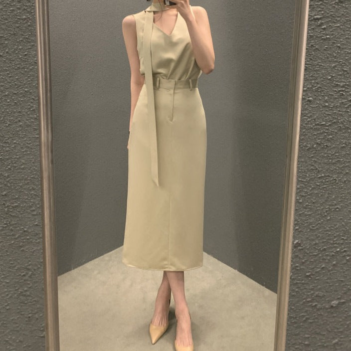 アイボリーのVネックボウタイノースリーブセットアップを着た女性の全身写真