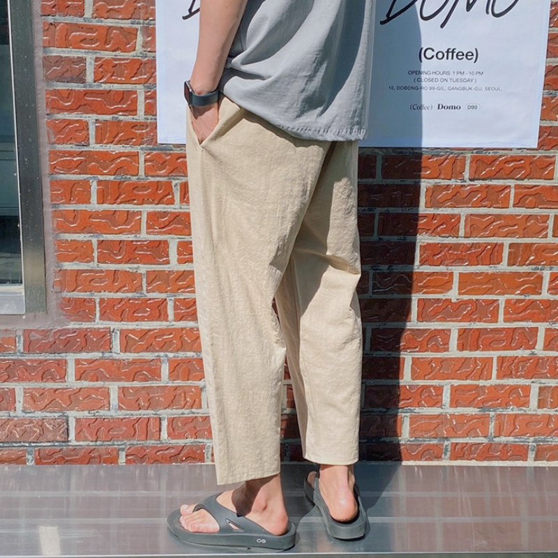 グレーTシャツ×ベージュアンクル丈パンツの後ろ姿
