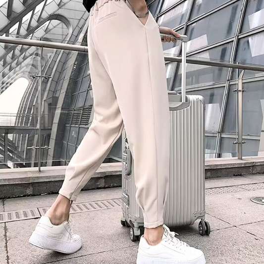 30代メンズ向けタック入りジョガーパンツを空港風の背景で着用した後ろ姿