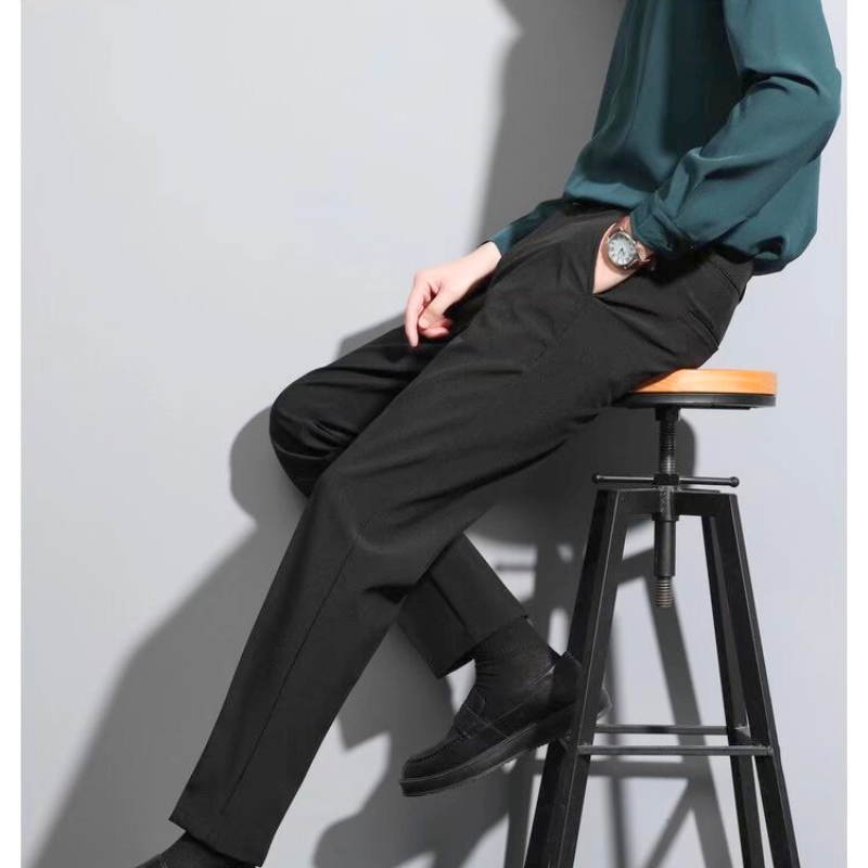 ブラックパンツを履いた30代メンズの横向き座りポーズ