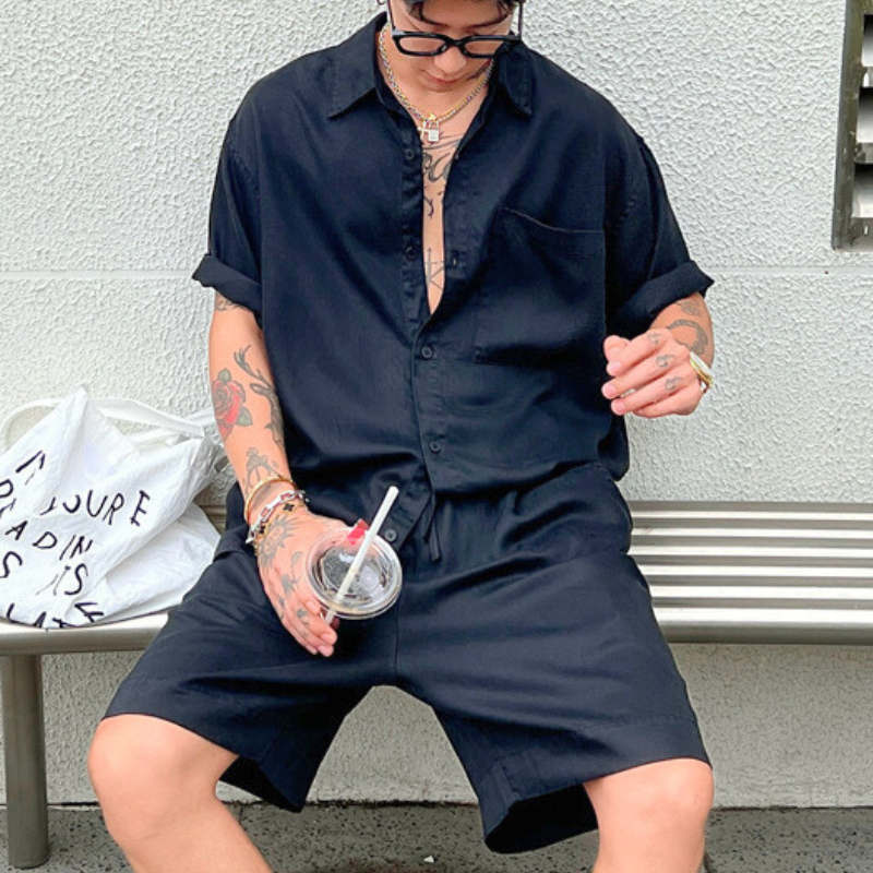 涼感ポリエステル素材のブラック サマーセットアップ ショートパンツを穿いた30代男性のイケオジ