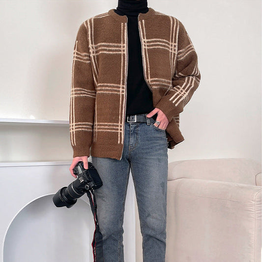 カメラを持ったポーズでチェック柄ニットジャケットの落ち着いた雰囲気を表現