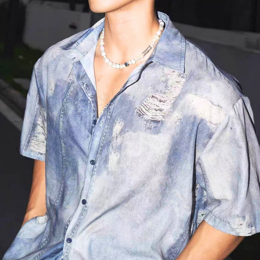 フェイクデニムの半袖シャツをアップで撮影。リアルなダメージ加工と開襟デザインが特徴。