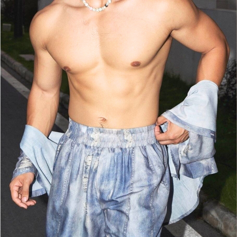 上半身裸でハーフパンツのみ着用のシーン。軽やかな素材感とウエストのゴム仕様が伝わる。