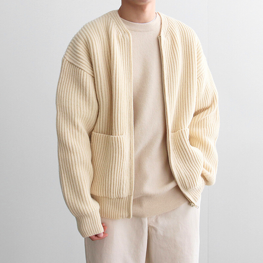 アイボリーの太リブニットカーディガンを羽織った30代メンズの秋冬コーデ。