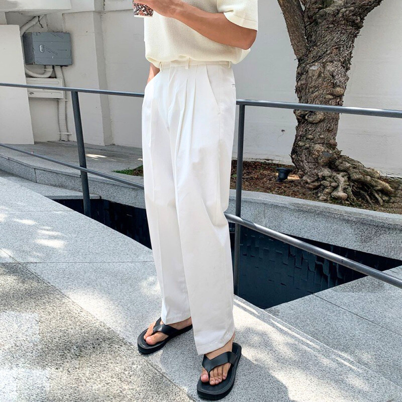 屋外の街中で白パンツを穿いた男性の横姿
