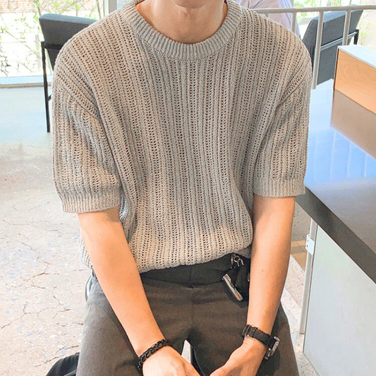 グレージュの透かし編みニットを涼しげに着こなす30代男性のカフェスタイル