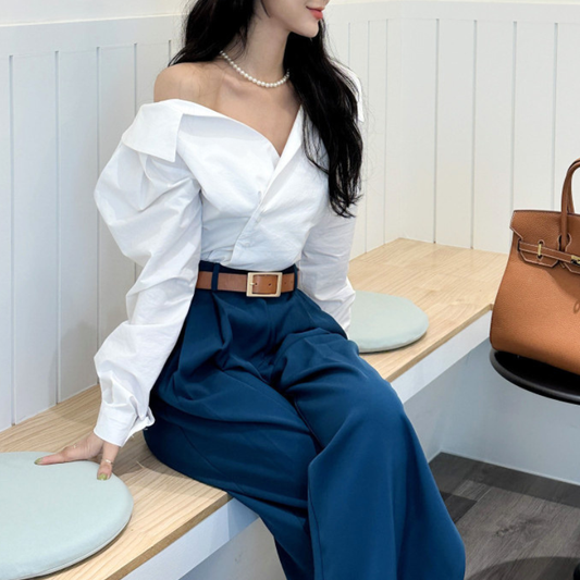 ホワイトのアシンメトリーカシュクールブラウスを着用した座りコーデ