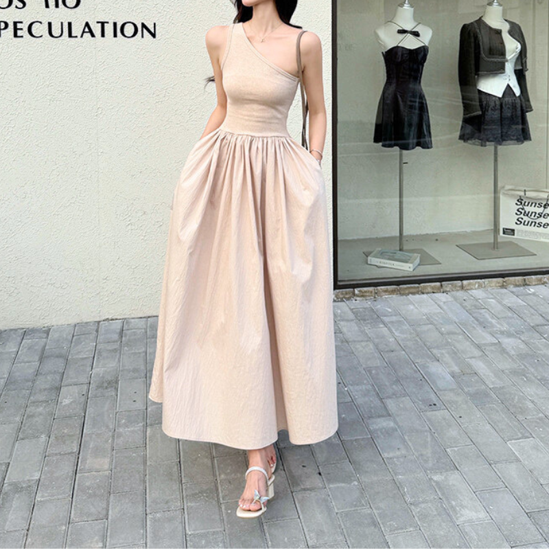 手を腰に当てたポージングのピンクワンショルダーワンピ