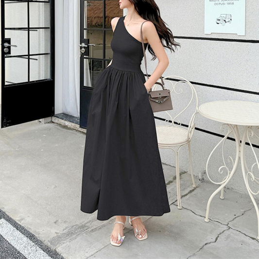 横向きで立つ黒のワンショルダーワンピ女性