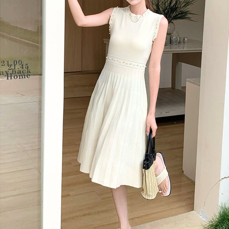 ホワイトワンピースを玄関前で着用し、柔らかい印象に映った写真