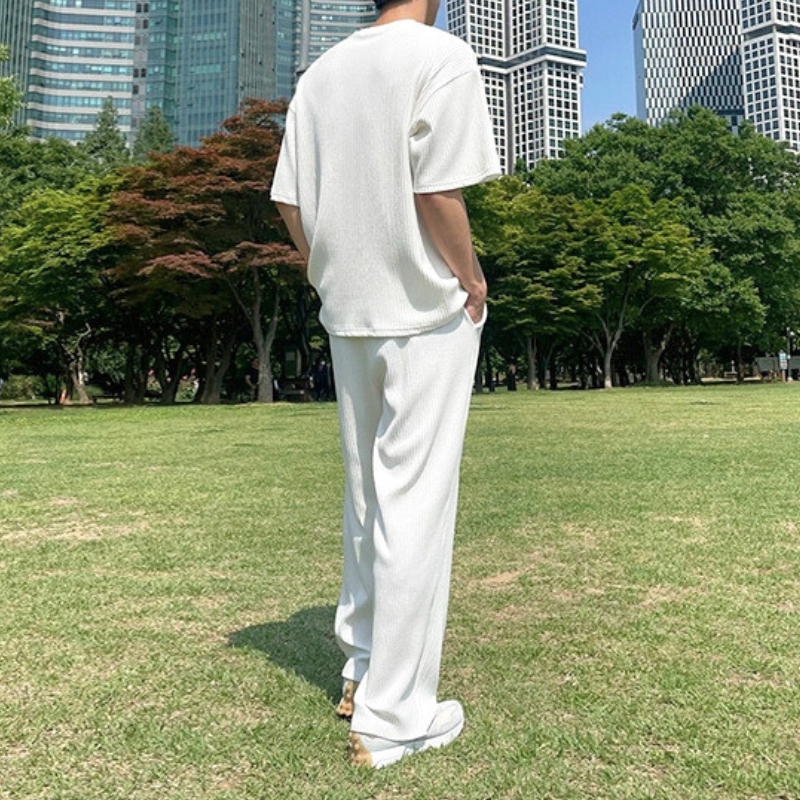 公園で白のロングパンツセットアップを着る後ろ姿
