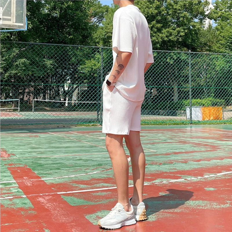 ショートパンツセットアップで立つ男性の後ろ姿(バスケットコート)