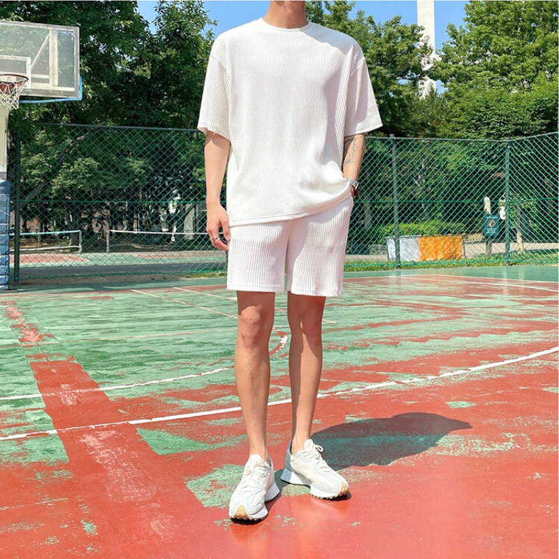 バスケットコートで白ショートパンツセットアップを着る正面ショット