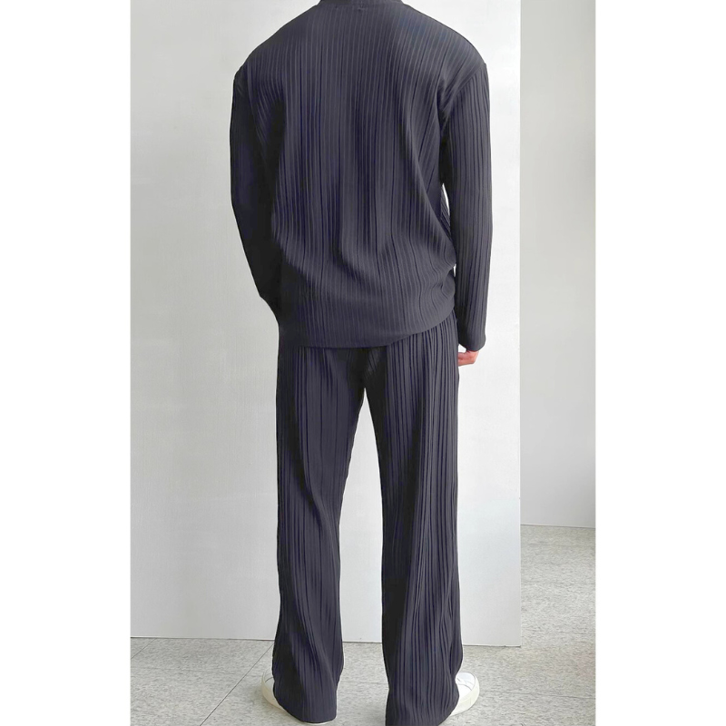 ブラックのプリーツセットアップを後ろ姿で見せたスタイリッシュな印象