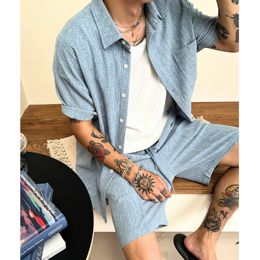 ブルーのプリーツ風セットアップをラフに着こなす男性