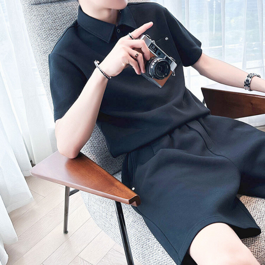 ブラックのポロセットアップを着て椅子に座る男性