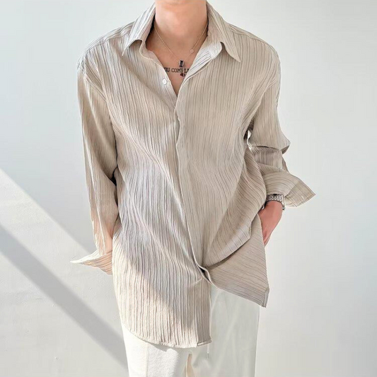 シャツをラフに羽織ったスタイルで立つ男性