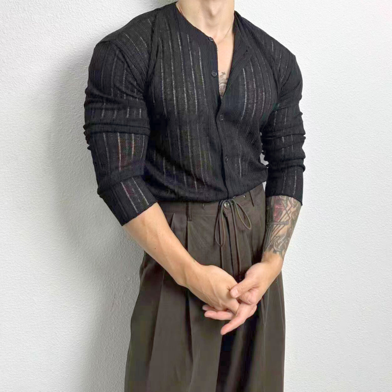 ブラックカーディガンを片腕まくってポーズする男性