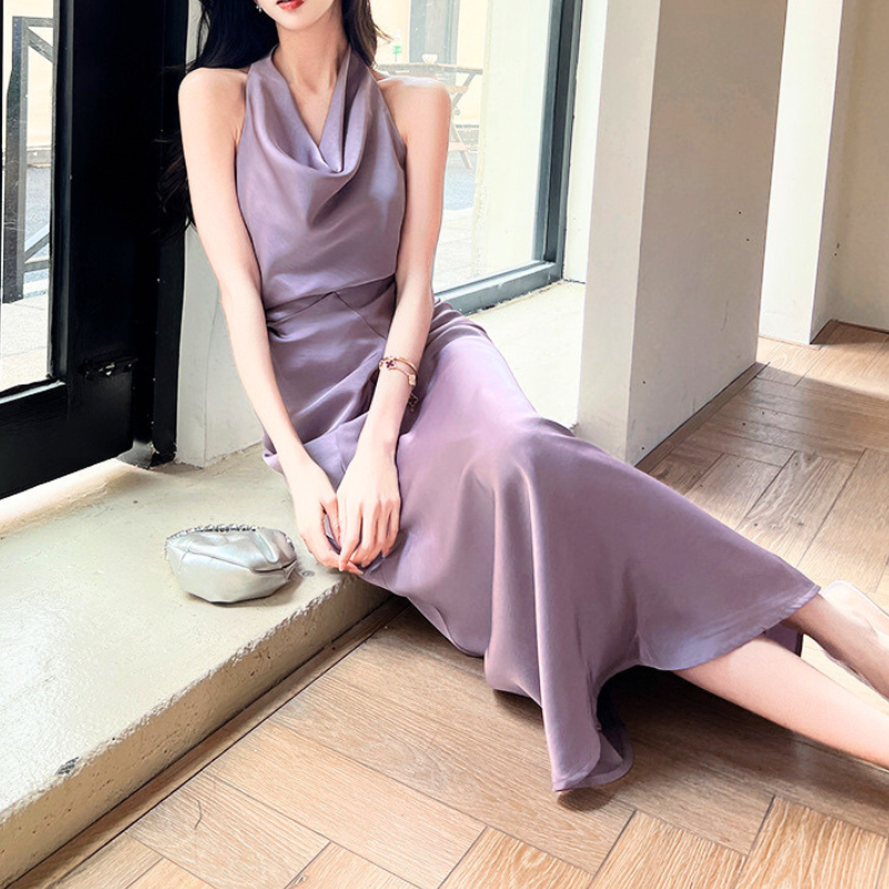 パープルのホルターネックワンピースで座って微笑む女性