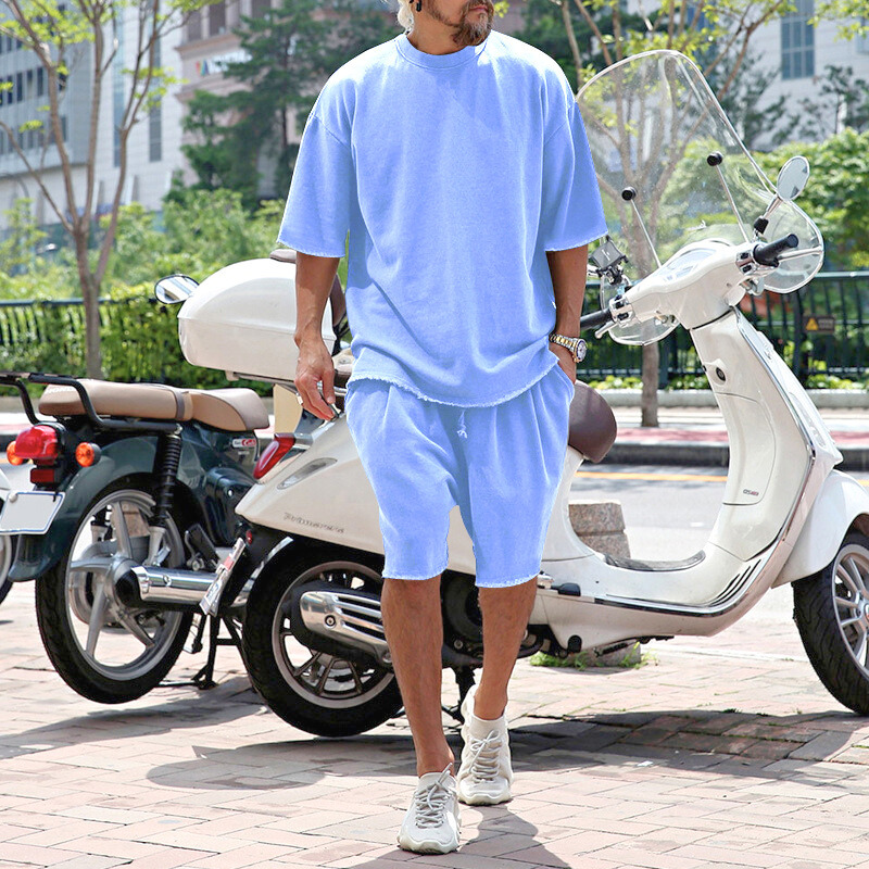 ライトブルーのナイロン混サマーセットアップを着用した男性(バイク前)
