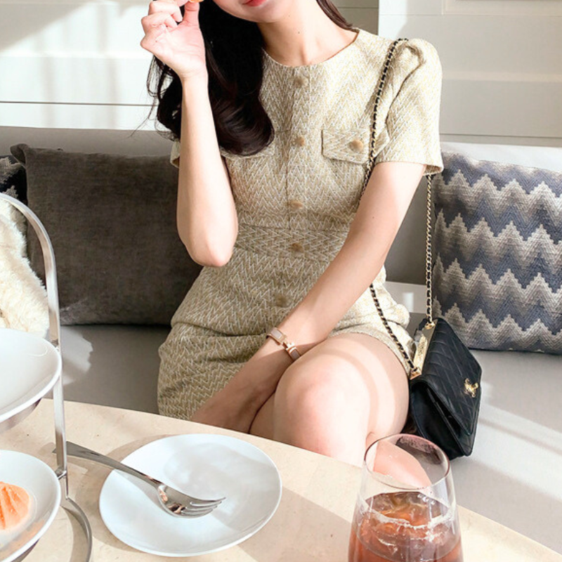 カフェでおしゃれに座る女性が着用する清楚なツイードミニワンピース