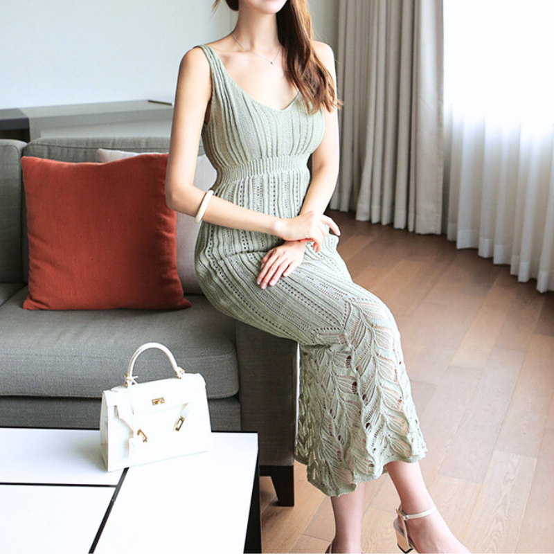 室内で座るモデルが着こなすカーキのかぎ編みワンピース