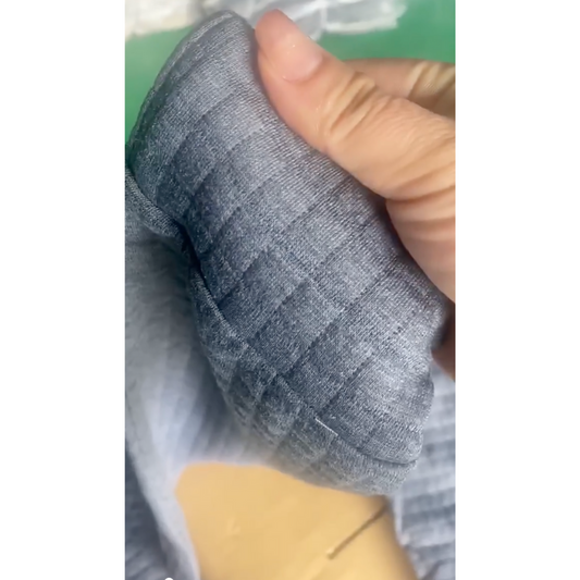 グレー生地のワッフルキルトの質感を手で確認している様子