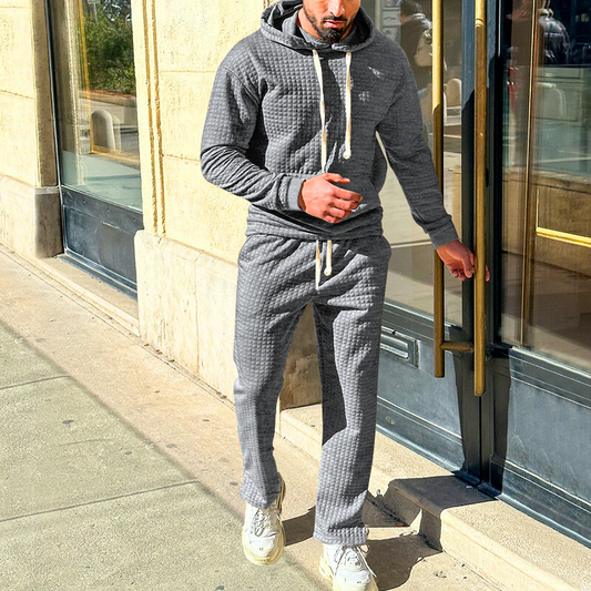 グレーのワッフルキルトセットアップを屋外で着用する男性