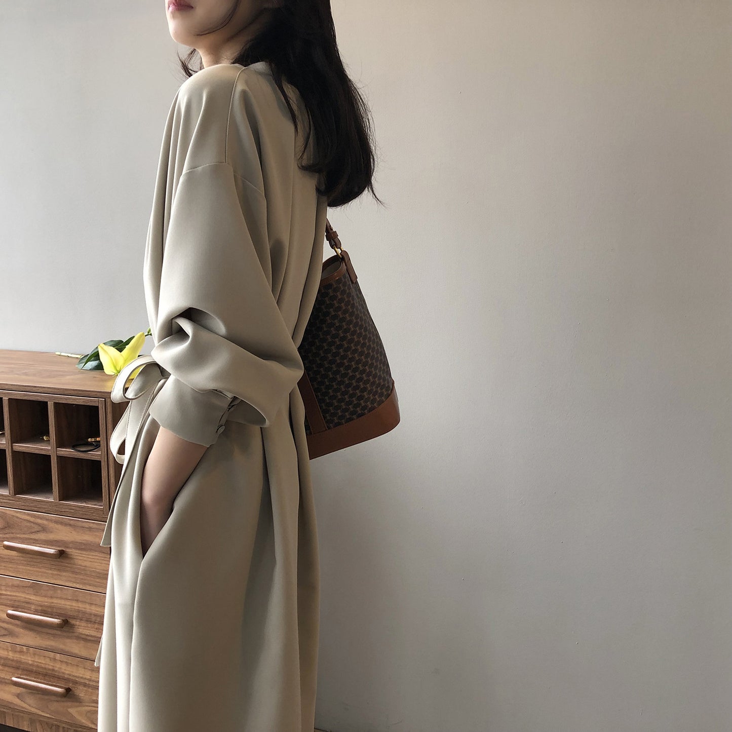 ベージュのワンピースを後ろから撮影。ゆったり袖と落ち感が華奢見えをサポート