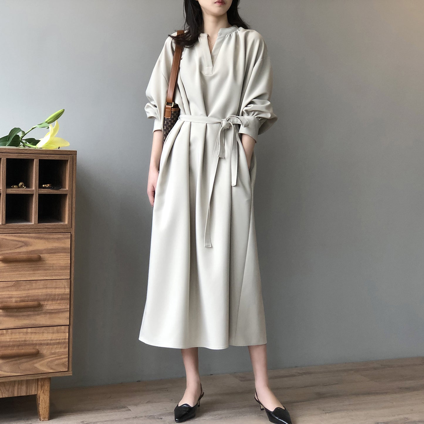 ベージュのリボン付きキーネックフレアワンピースを正面から撮影。ふんわりAラインが上品な印象