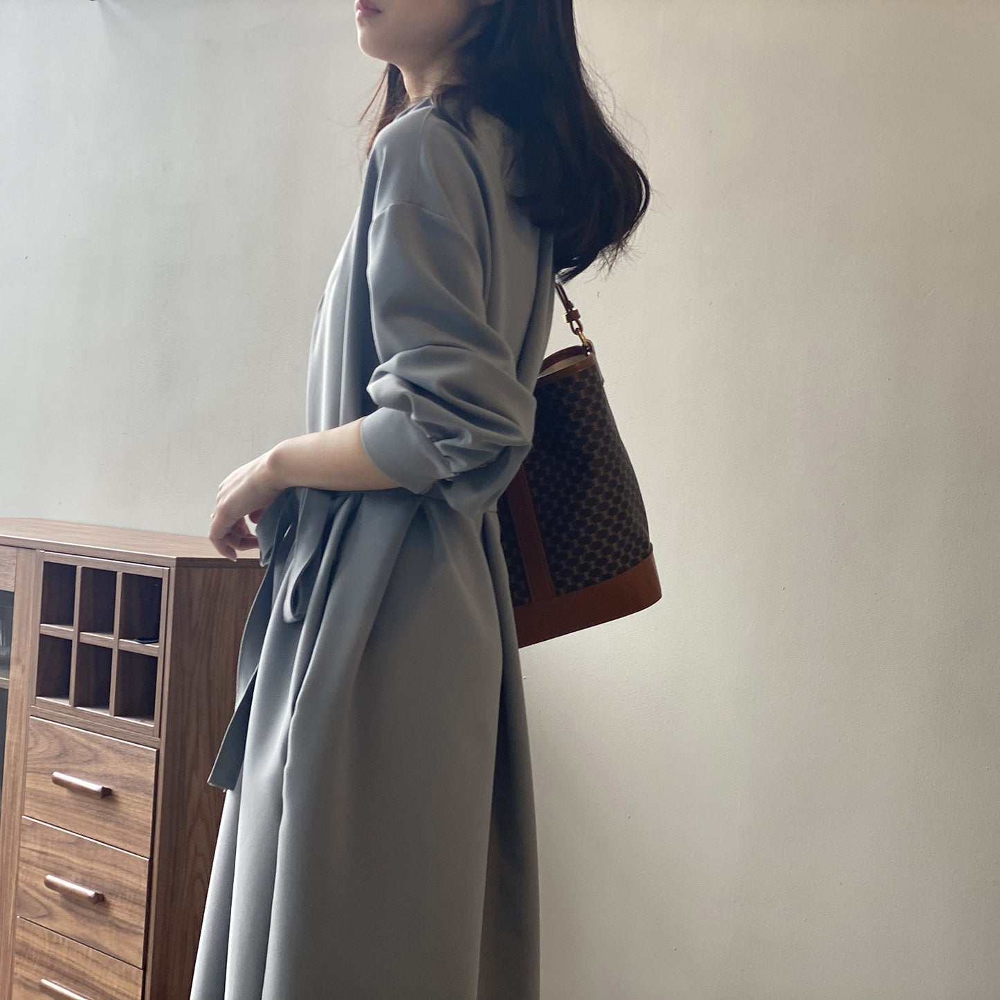 ブルーのワンピースを後ろから撮影。シンプルなデザインが上品な印象を際立たせる