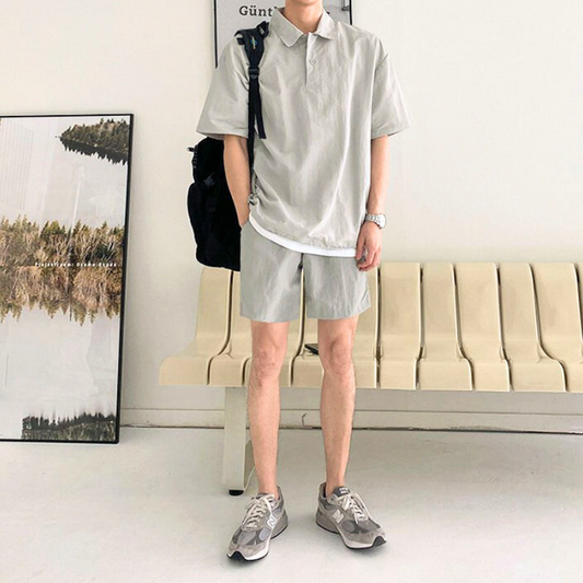 軽やかなグレーセットアップを着て立つ男性全身