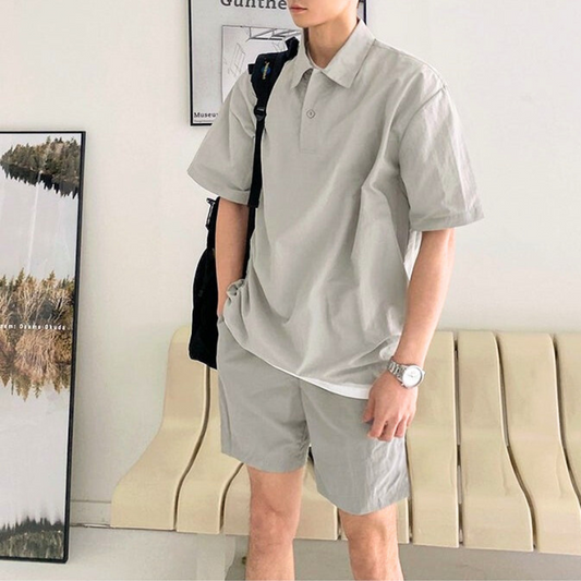 シャリ感のあるポロシャツとハーフパンツのセットアップを着た男性モデル