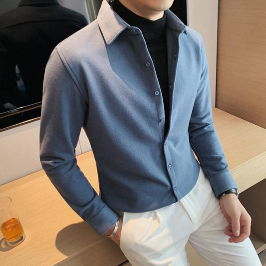 肘を曲げたポーズで見せるブルーのレイヤードシャツコーデ