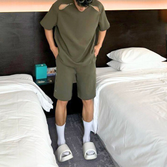 カーキの肩ジップ半袖とハーフパンツのセットアップを着た男性の正面立ち姿