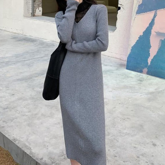 グレーのタイトリブニットワンピースを着た女性が屋外で上品なシルエットを見せる全身コーデ