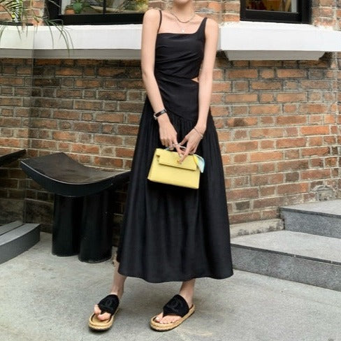 ブラックのアシンメトリーカットアウトフレアワンピースを正面から撮影。モード感とセクシーさが際立つ