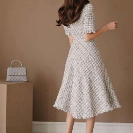 背面から撮影したフリンジツイード風フレアワンピースで、背面ファスナーやウエストラインをアピール