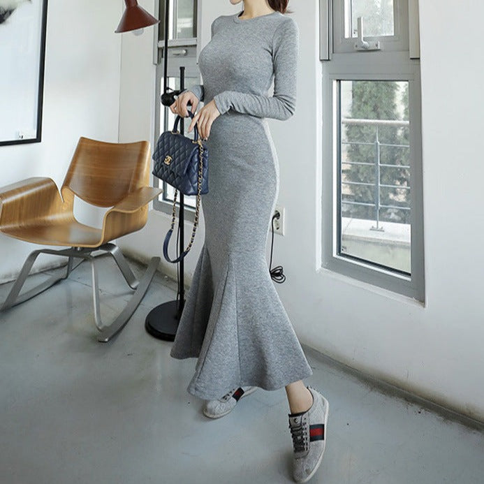 斜め後ろから見たグレーワンピースで、ヒップラインとマーメイド裾の動きが美しいシルエット