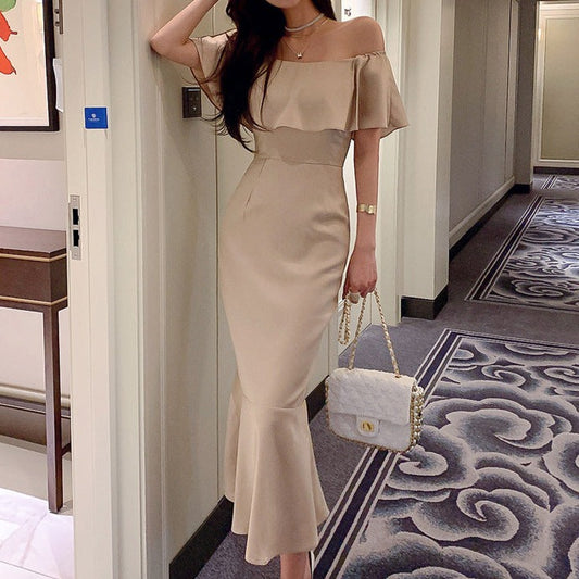 ベージュのオフショルフリルマーメイドワンピースを正面から撮影し、華やかなフリルと肩見せが際立つ